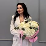 Три белых гортензий в круглой розовой упаковке