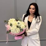 Три белых гортензий в круглой розовой упаковке