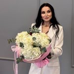 Три белых гортензий в круглой розовой упаковке
