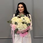 Три белых гортензий в круглой розовой упаковке